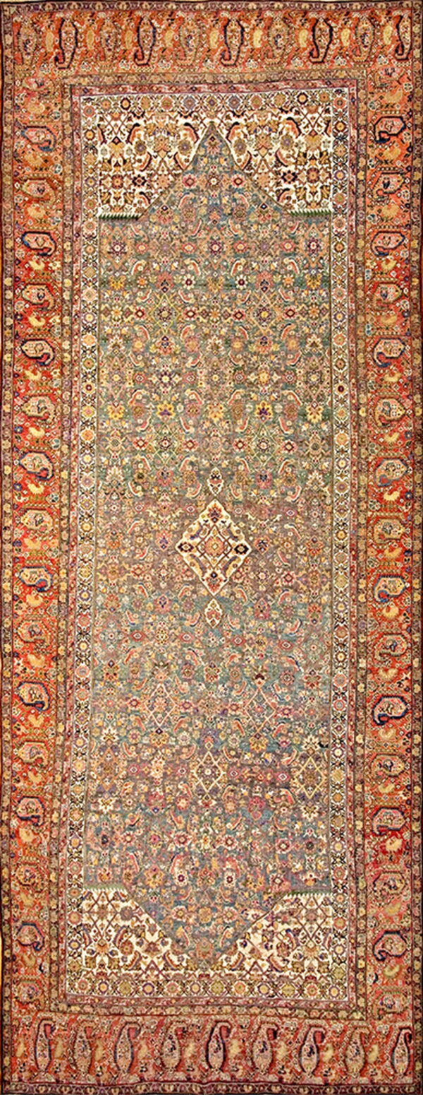 Ornate traditional rug with a muted sage field, intricate floral patterns, and bold rust paisley borders.