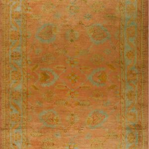 Faded coral and rust orange rectangular rug with an all-over traditional floral pattern in teal and gold.
