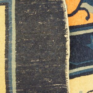 Detail shot comparing low-pile cream and blue geometric patterns with adjacent high-pile orange and navy blue rug patterns.
