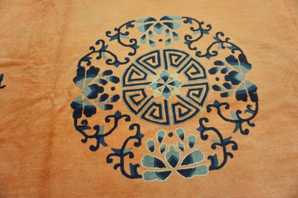 Plush peach rug detail showing a round geometric and floral medallion in navy and teal blue.