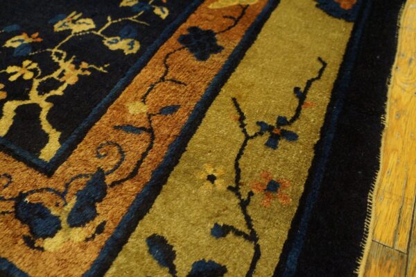 The high pile rug displays navy, rust, and moss green stripes with floral branch motifs on light wood flooring.