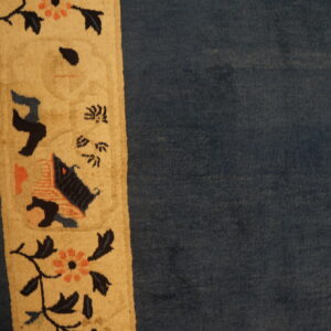 Blue rug with decorative border design.