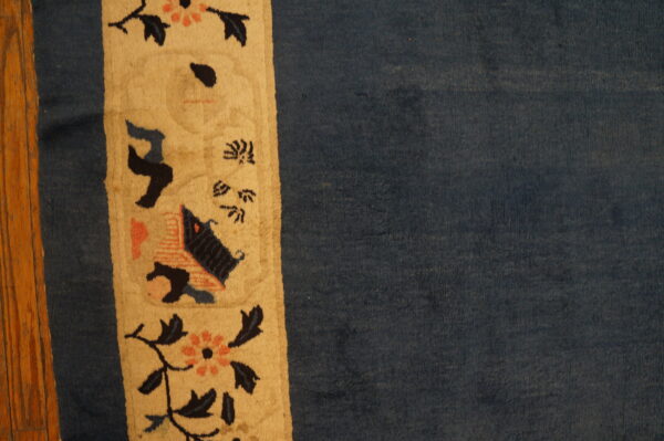 Blue rug with decorative border design.