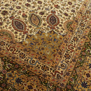 Traditional rug with complex cream, gold, green, and multi-colored floral patterns and detailed borders.