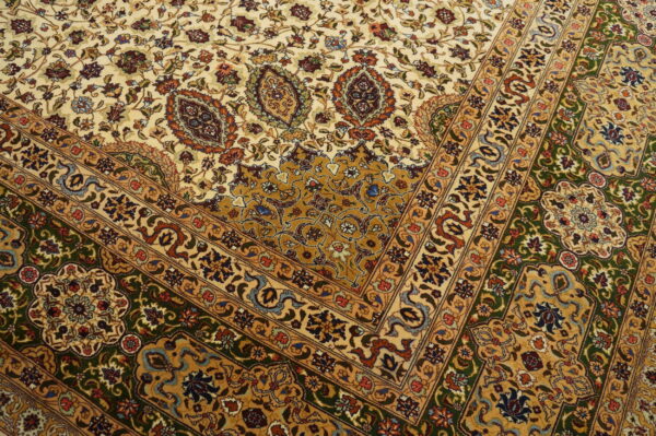 Traditional rug with complex cream, gold, green, and multi-colored floral patterns and detailed borders.