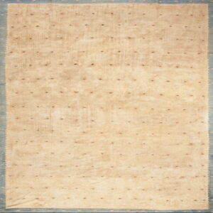 Beige rug field scattered with small red and navy diamonds, bordered by wide scalloped blue banding.