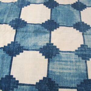 Blue and white flatweave rug displaying a geometric grid pattern with stepped cross intersections.