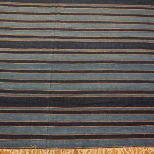 Alternating bands of navy and teal blue with thin orange stripes, visible fringe on wood floor.