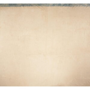 Cream rug with a scalloped edge detail separating the creased field from the textured blue border.