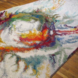 High-pile rug with an abstract multicolor swirling pattern on a cream background, lying on wood floors.