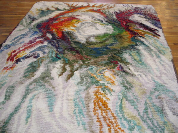 Multicolor abstract rug with high shag pile and dense swirling colors over a wood floor.