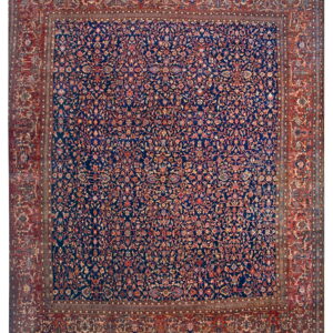 Intricate floral rug featuring a dark blue field framed by a wide, patterned rust red border.