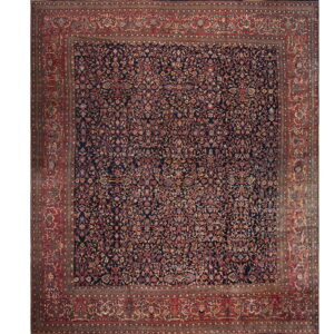 Traditional rug featuring an all-over floral pattern on a navy blue field with wide red borders.