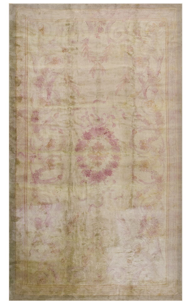 Muted, distressed rug featuring a classical floral pattern in pale rose pink and dusty beige colors.