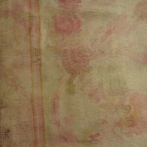 Distressed, textured rug pile featuring muted pink floral shapes and faded vertical stripes on a beige ground.