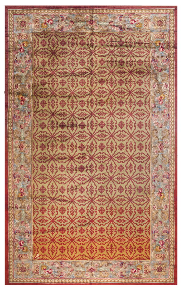 Gold rug with a repeating red geometric lattice pattern and a detailed floral tapestry border.