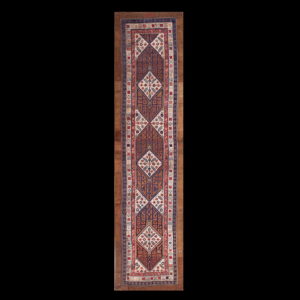 Traditional runner rug featuring interlocking brown, navy, red, and cream geometric diamond patterns.