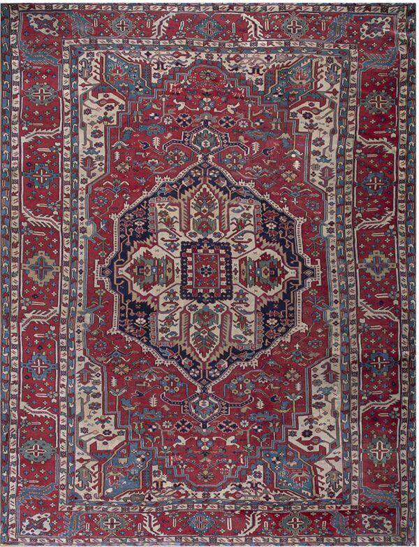 Traditional red rug with a central medallion and detailed geometric motifs in navy, teal, and beige.