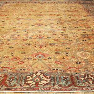 Gold field rug featuring intricate red, rust, and teal traditional patterns on hardwood flooring.