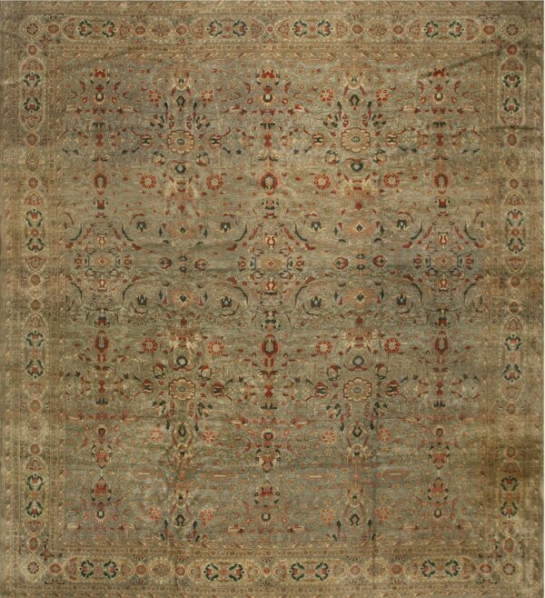 Traditional rug with a muted blue-gray field, detailed floral motifs, and wide khaki-toned borders.