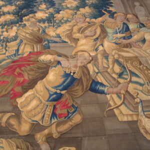 A pictorial flat-woven textile shows classical figures, including one kneeling with a bow, in gold, blue, and red.