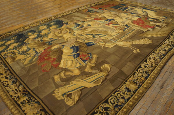 Large, low-pile rug displays a figural narrative pattern in gold, navy, and brown on distressed wood planks.