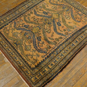 Rust and indigo rug with geometric motifs and borders rests on natural, warm-toned wood flooring.