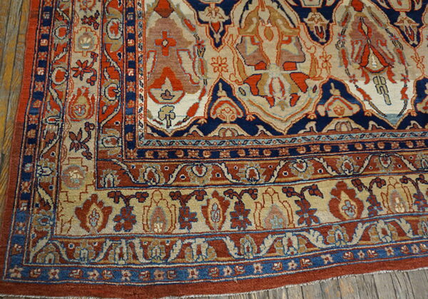 Ornate navy, rust, and beige traditional patterned rug detail rests on rustic wood planks.