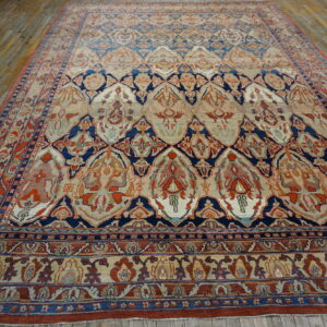 Ornate navy, rust, and beige patterned rug covers aged, narrow wood plank flooring.