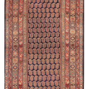 Runner rug with a navy blue field, repeating red paisley pattern, and complex geometric borders.