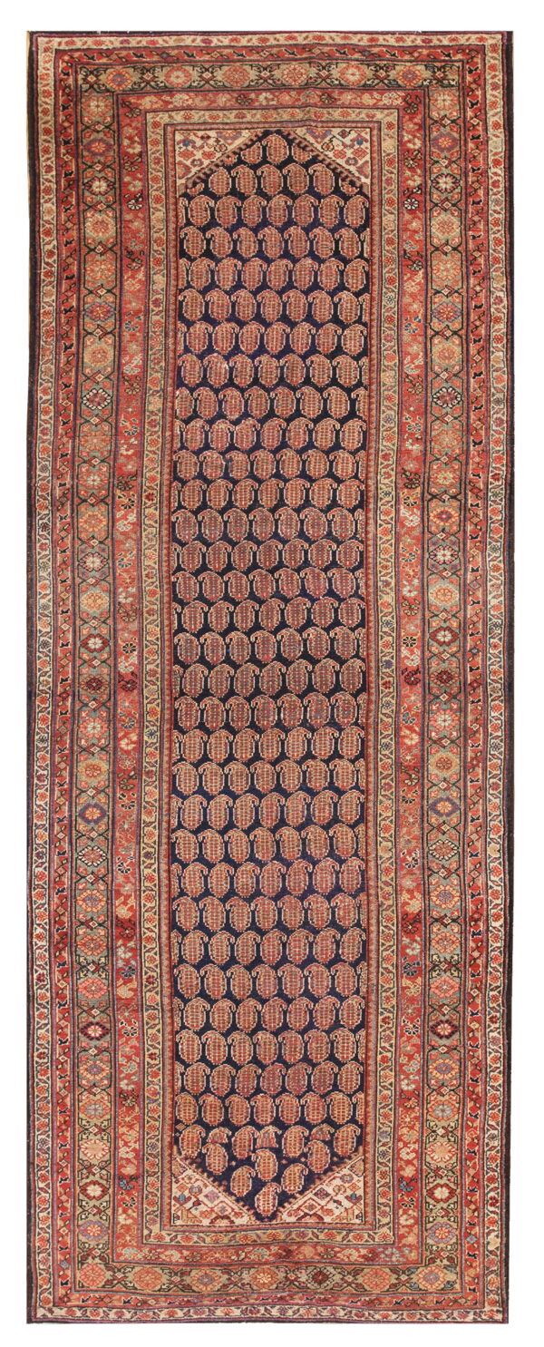 Runner rug with a navy blue field, repeating red paisley pattern, and complex geometric borders.