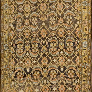 Rectangular rug featuring a dark field, gold border, and repeating tan, peach, and blue floral motifs.