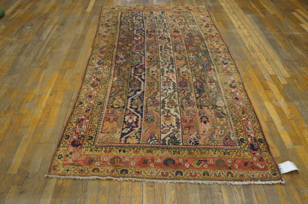 Low-pile rug with complex vertical panels in coral, navy, and yellow rests on vintage wood flooring.