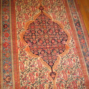 Traditional red, navy, and cream runner rug featuring an elaborate central medallion on a wood floor.