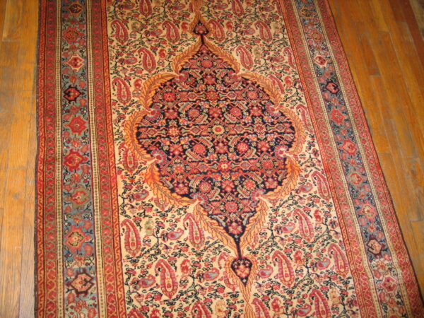 Traditional red, navy, and cream runner rug featuring an elaborate central medallion on a wood floor.