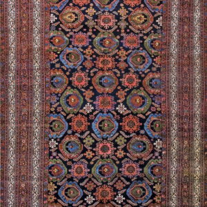 Dark runner rug with repeating colorful geometric medallions and wide borders in shades of red and ivory.