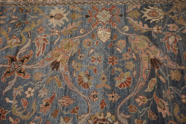 Intricate blue rug features a traditional floral design highlighted with rust, beige, and muted olive accents.