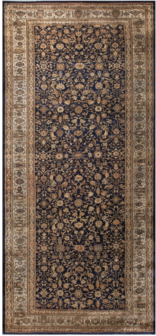 Traditional navy and tan rug with an intricate all-over floral design and wide decorative borders.