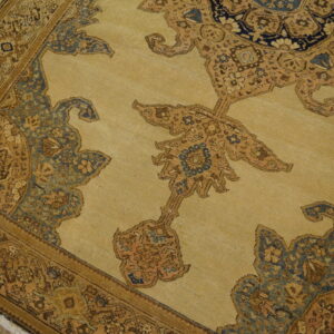 Traditional beige rug with intricate blue and brown medallion patterns rests on light hardwood flooring.
