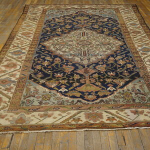 Intricate navy and ivory medallion pattern rug featuring muted blue and pink accents on wood planks.