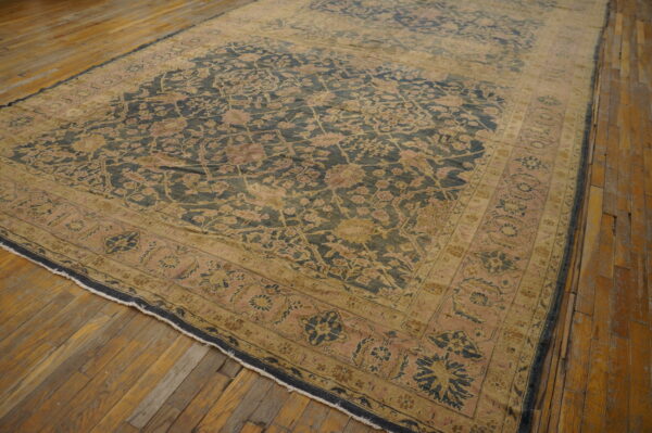 Low-pile rug featuring a distressed navy and rose floral pattern on light brown wood planks.