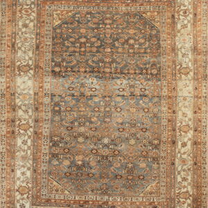 Full view of an ornate low-pile rug featuring a distressed blue field and intricate tan and rust multi-borders.