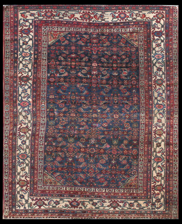 Deep navy rug featuring complex red and blue motifs with a wide stylized floral ivory border.