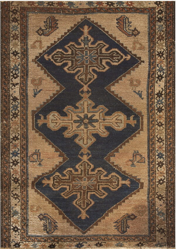 Geometric rug with dark blue diamonds and cross motifs on a beige field surrounded by patterned borders.