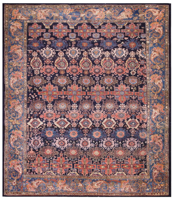 Dark blue rug with alternating bands of geometric and medallion motifs in coral, rust, and light blue.