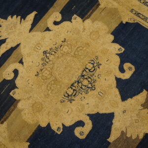 Low-pile rug in deep blue and gold featuring a large ornate medallion over diagonal stripes.
