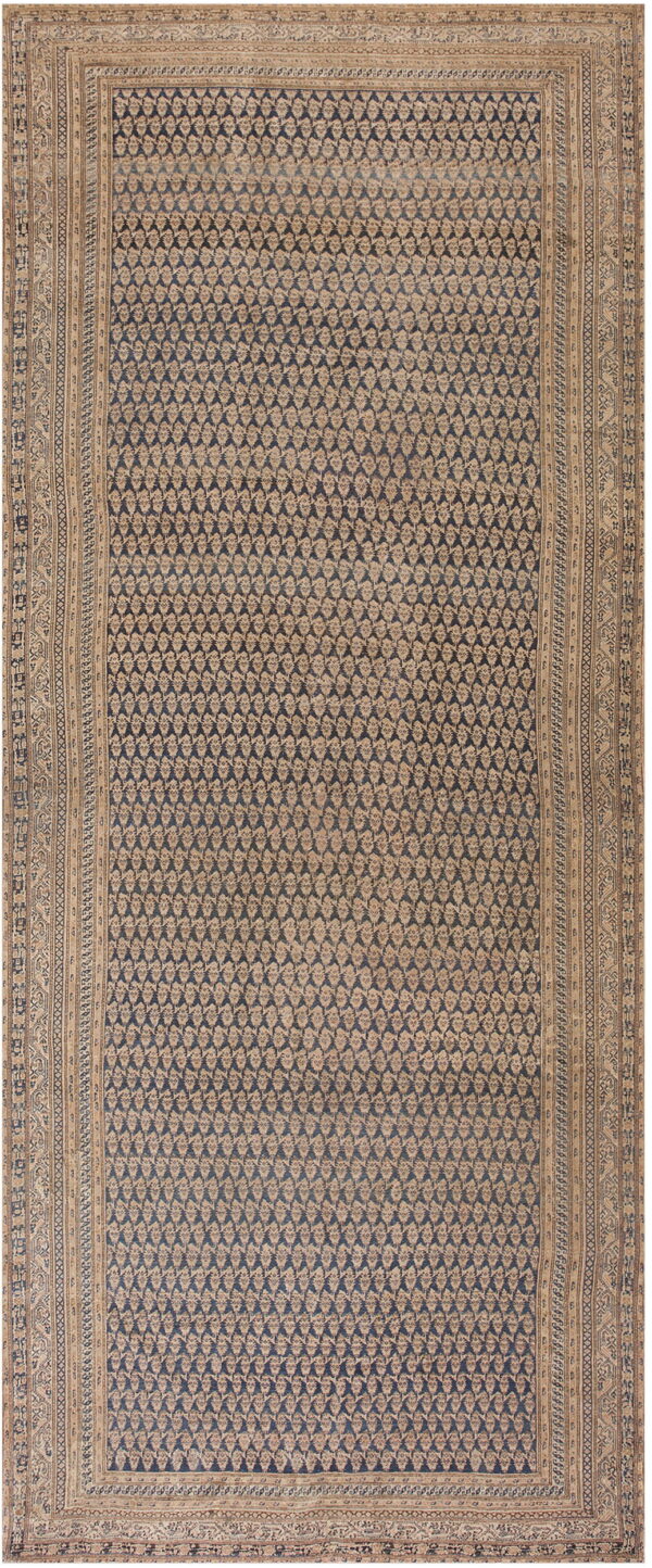 A rectangular rug displaying repeating tan floral patterns on a dark blue ground surrounded by complex tan borders.