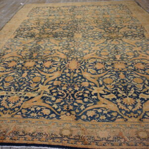 An elaborate dark blue and gold traditional rug featuring stylized floral and animal motifs on wood flooring.