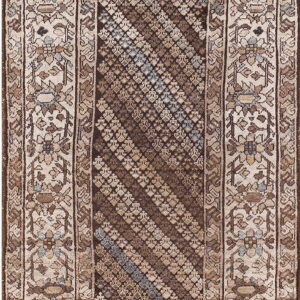 Brown, beige, and muted blue traditional rug with a diagonal striped center and a wide floral border.