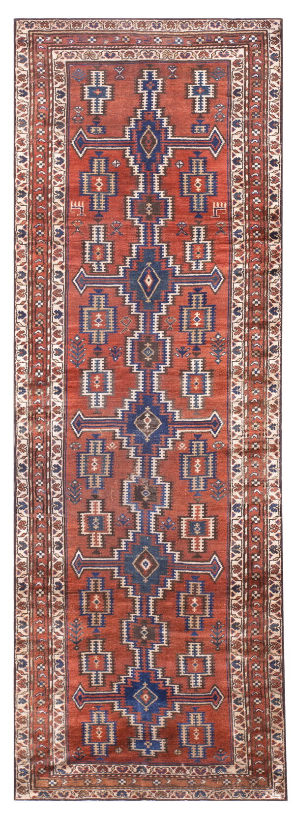 Geometric runner rug with a terracotta field, featuring repeated blue and beige tribal motifs.